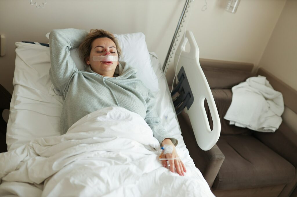 A woman lies in the hospital with a nose injury